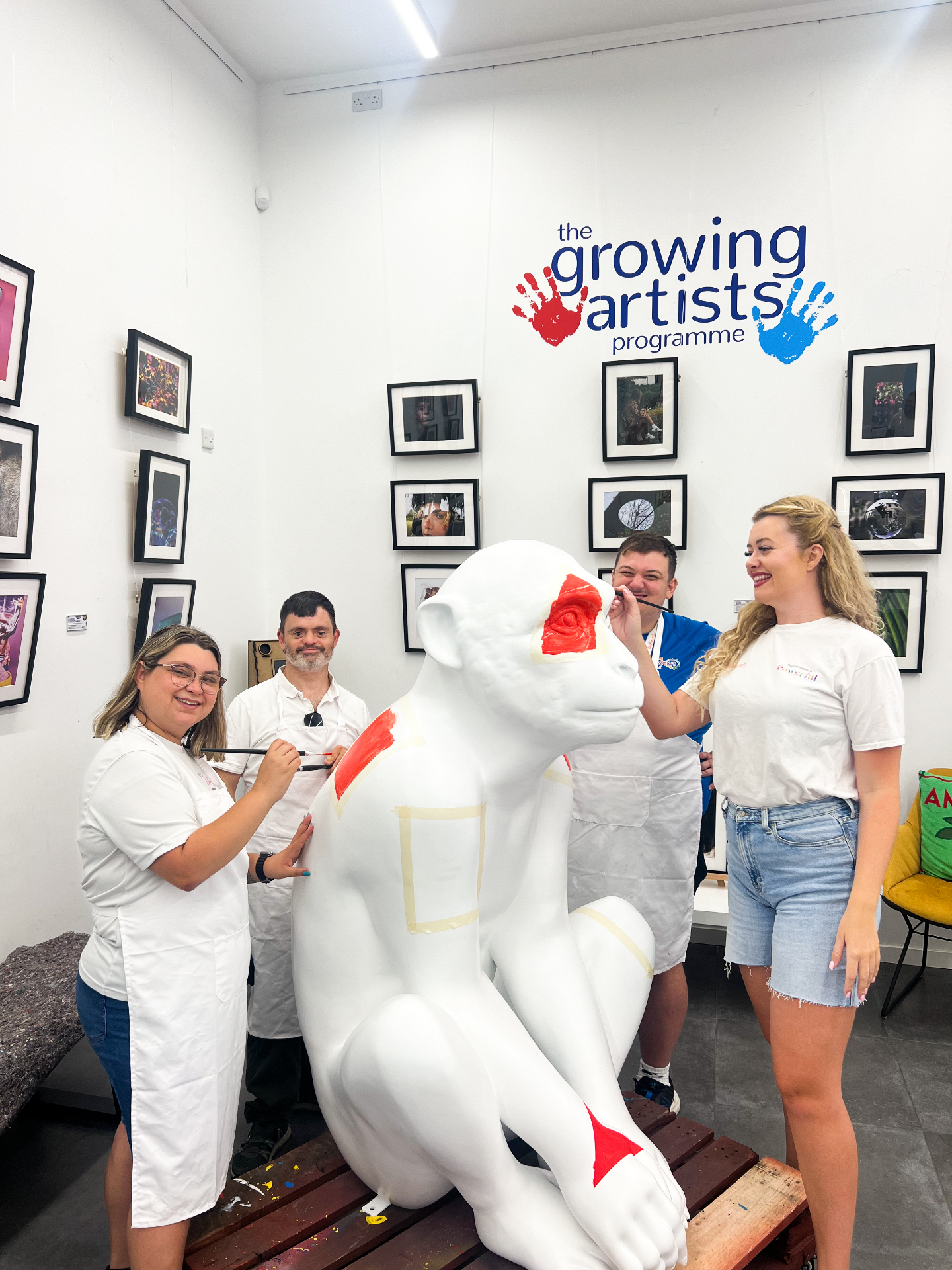 Artists posing with Princess Rainbow at the start of the paint session under the Growing Artists Programme sign