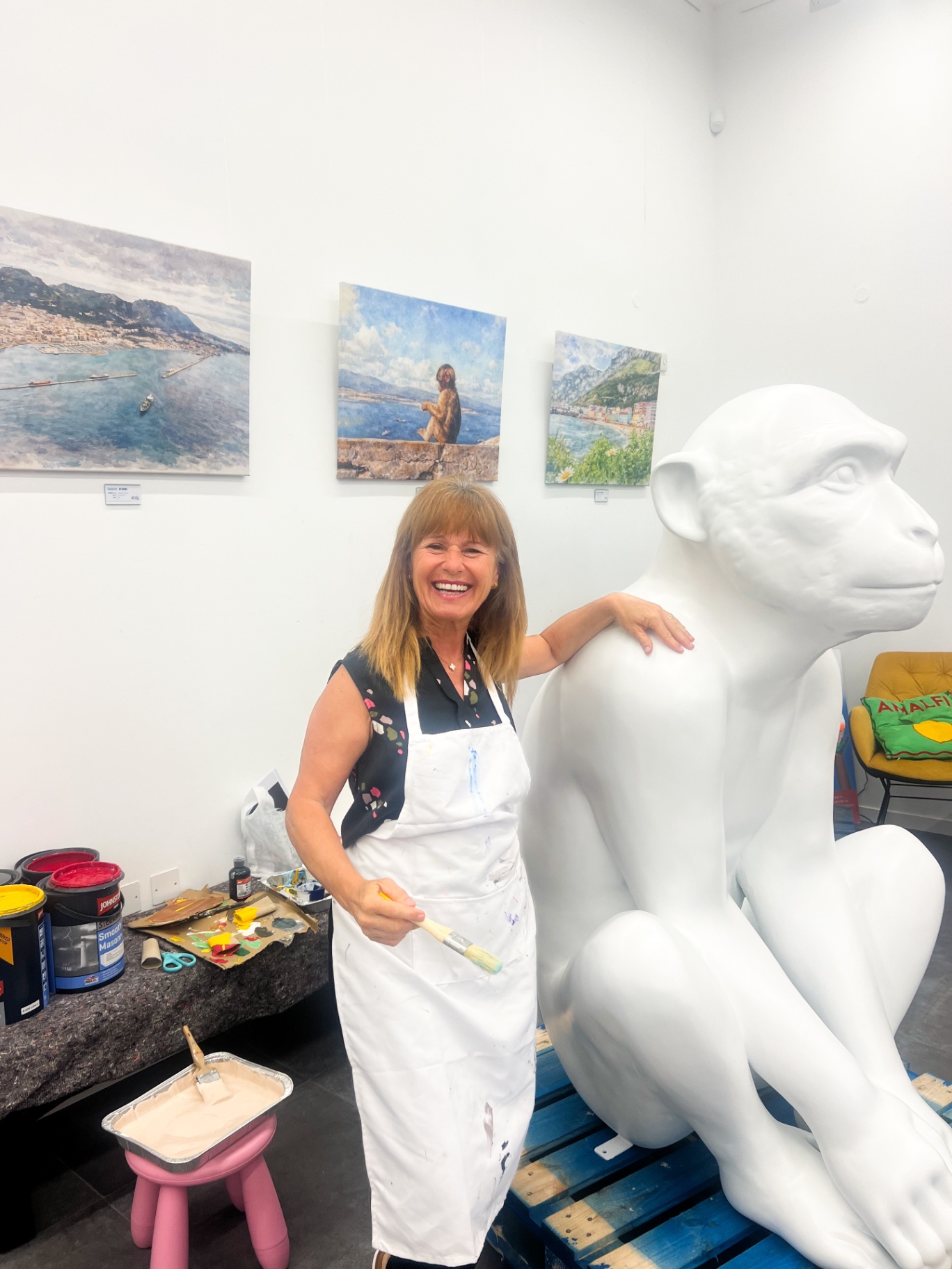 Artist smiling next to the unpainted Forest Fifi sculpture at the Growing Artists Programme studio