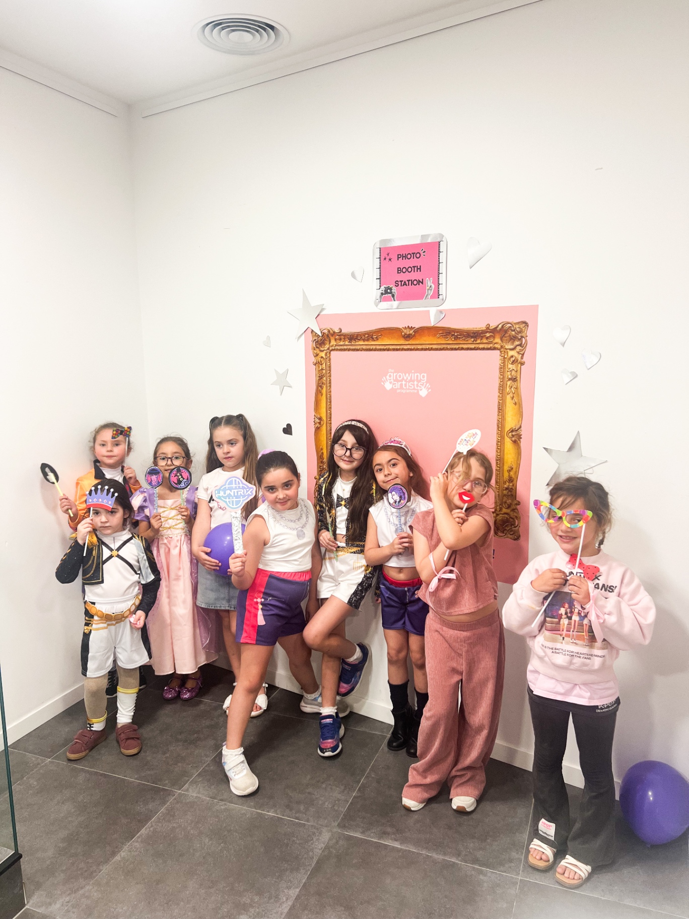 Party guests posing with props at the photo booth station