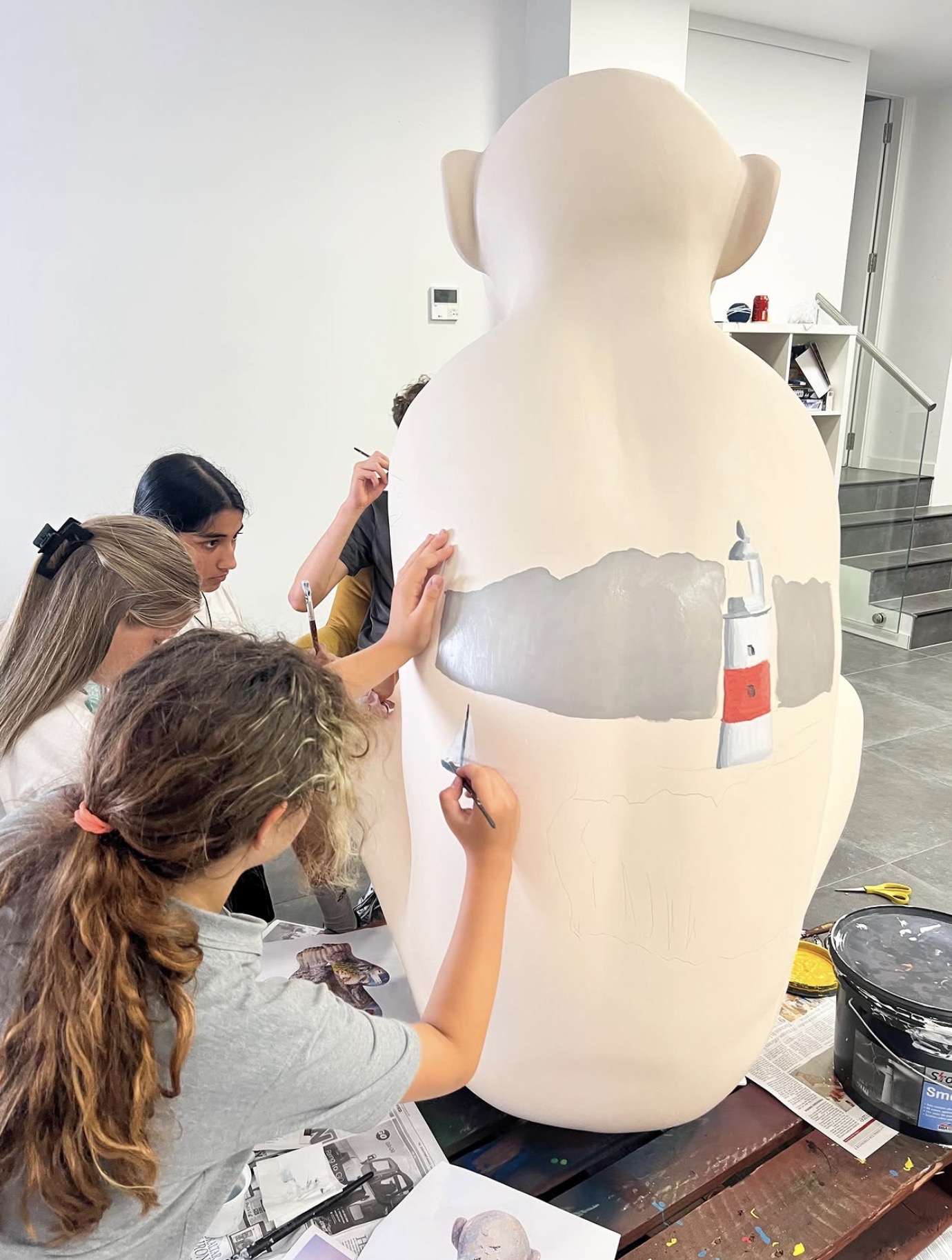 Young artists painting the Rock of Gibraltar onto a sculpture