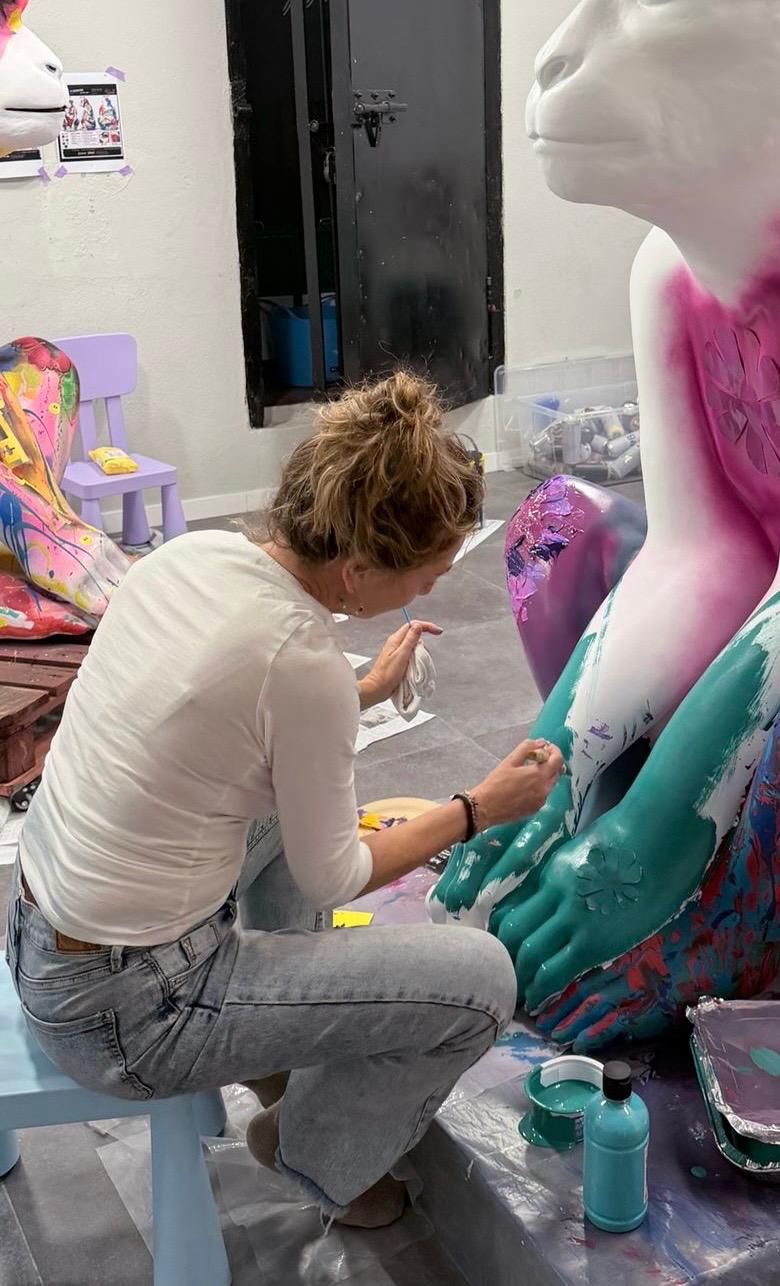 Nadine painting Coco's leg with turquoise and floral detail