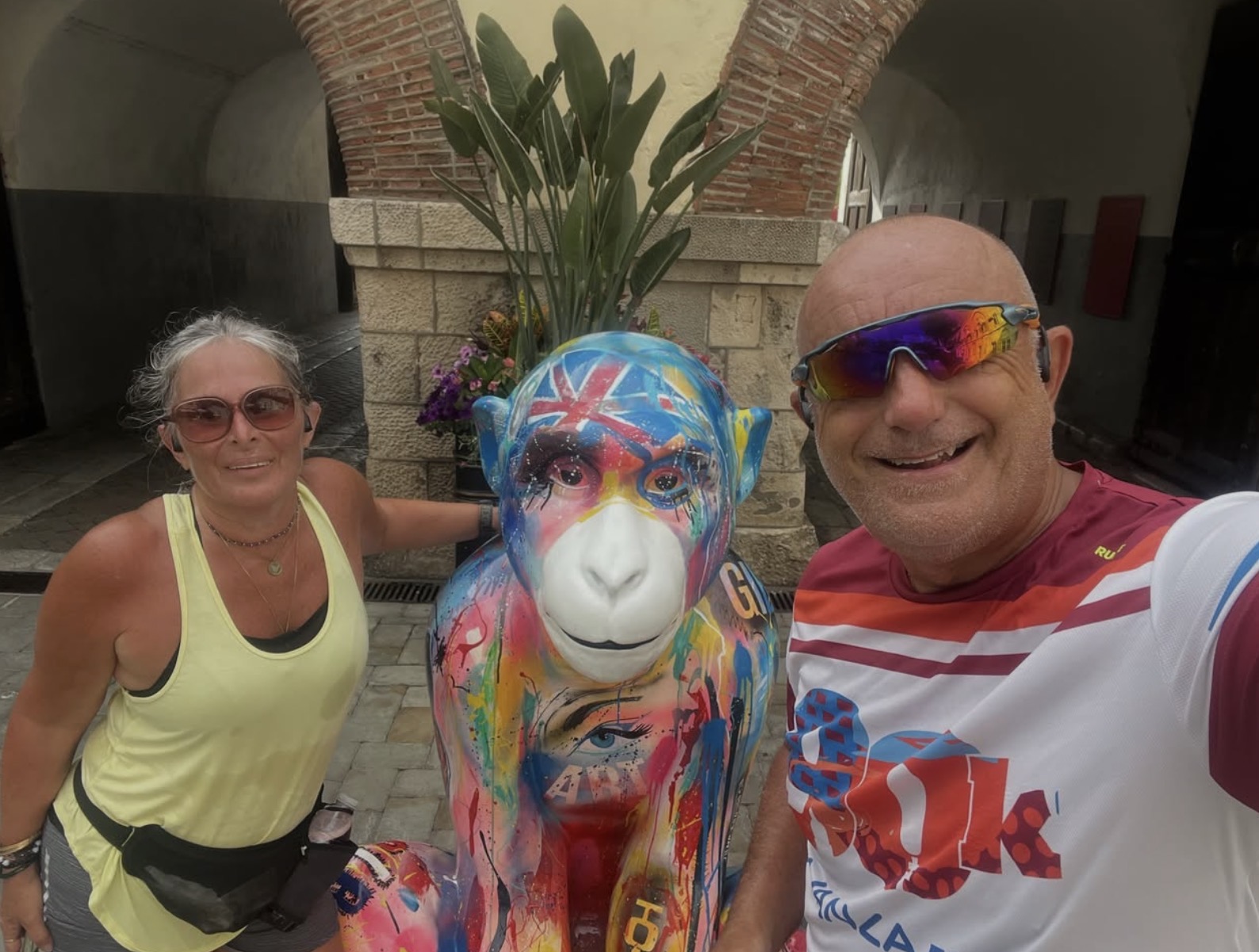 A couple taking a selfie with a colourful Barbary Macaque sculpture on the trail
