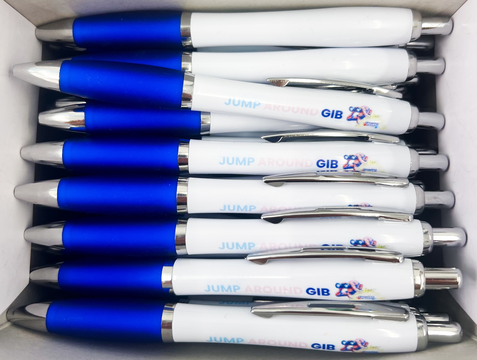 White and blue Jump Around Gib biro pens featuring the Growing Artists macaque artwork