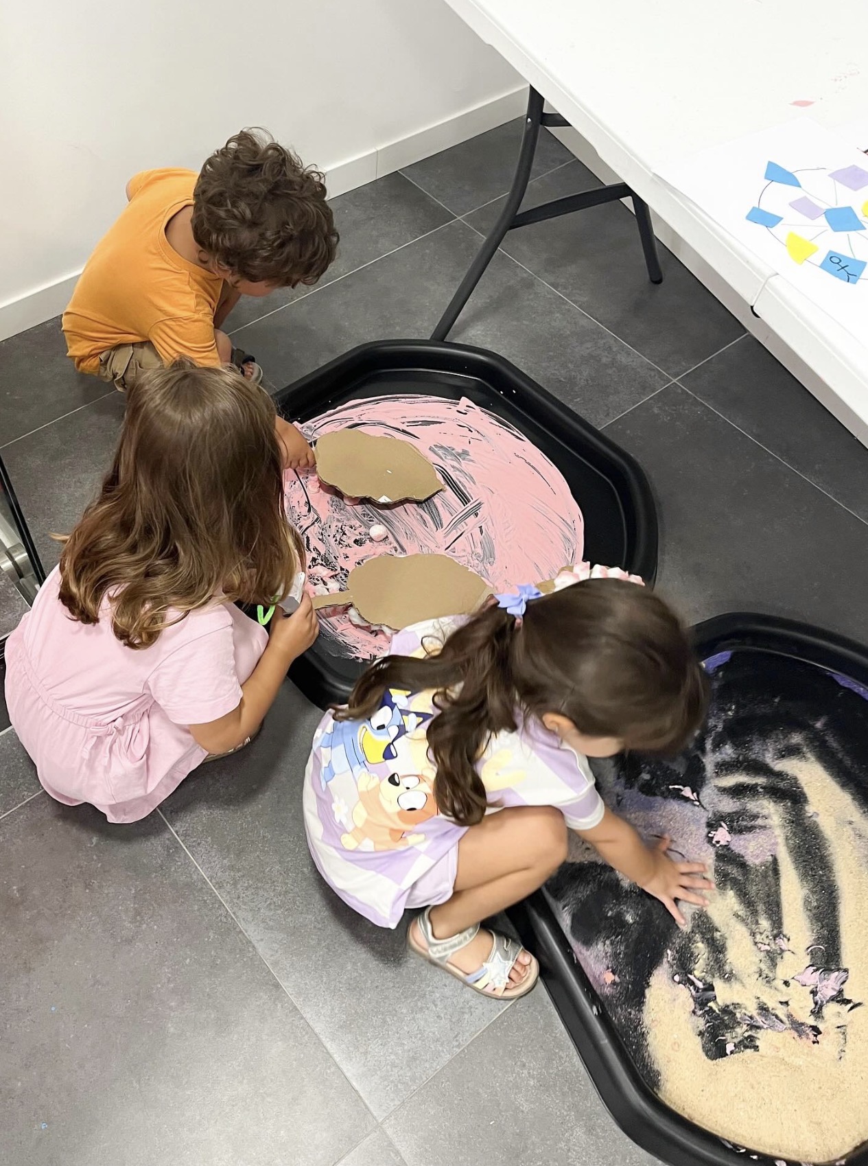 Toddlers exploring messy play stations at a Mini Makers class