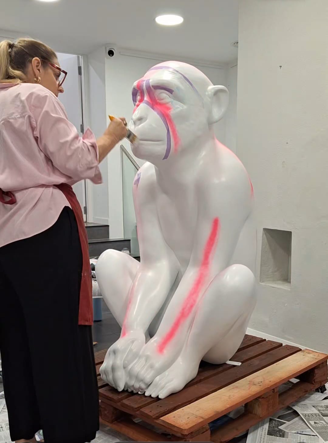 Gill Welland beginning Jubilee Jackson with the first pink and purple brushstrokes on the blank white sculpture