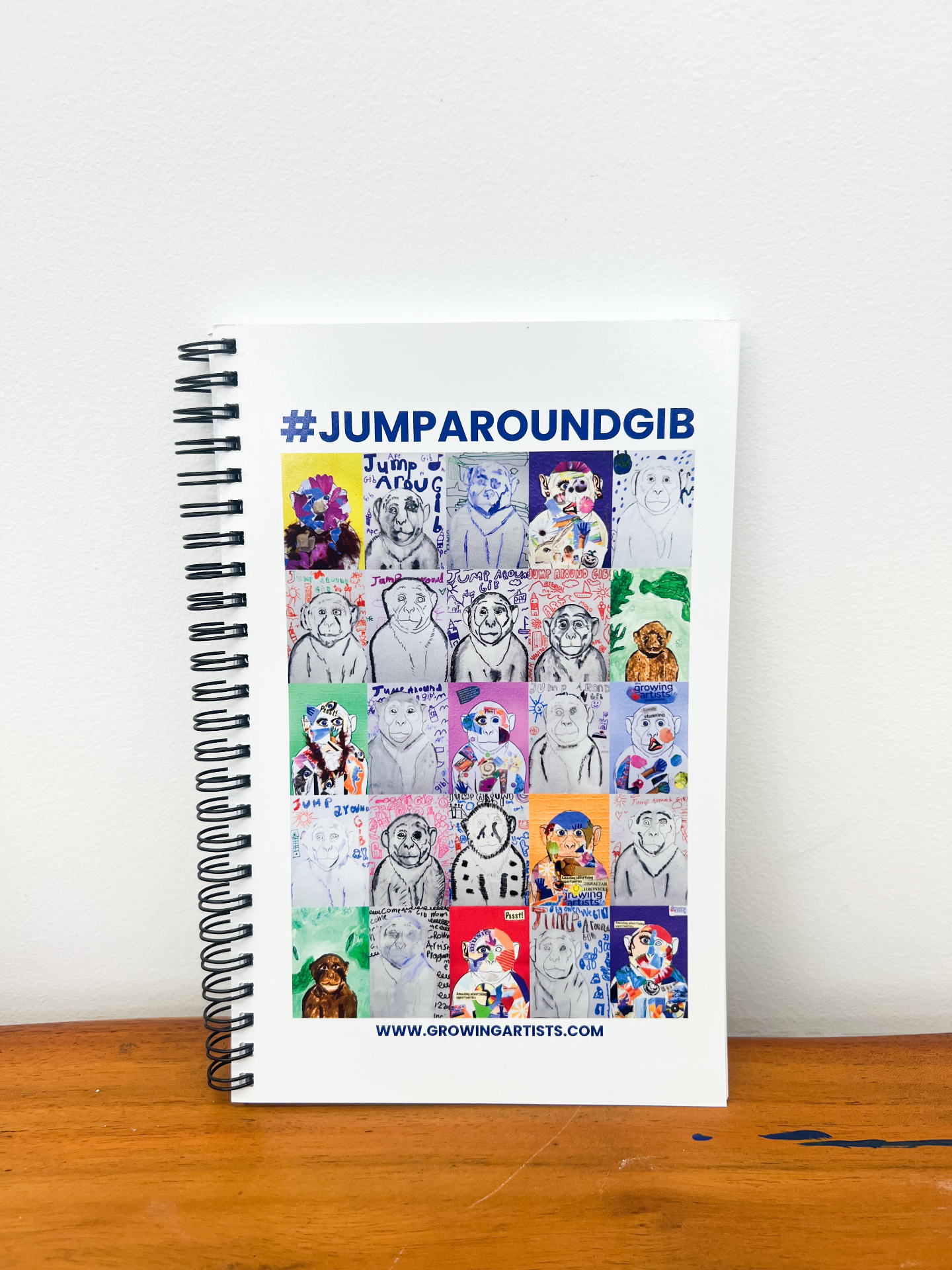 Spiral-bound #JumpAroundGib sketchbook with a collage of macaque artwork on the cover