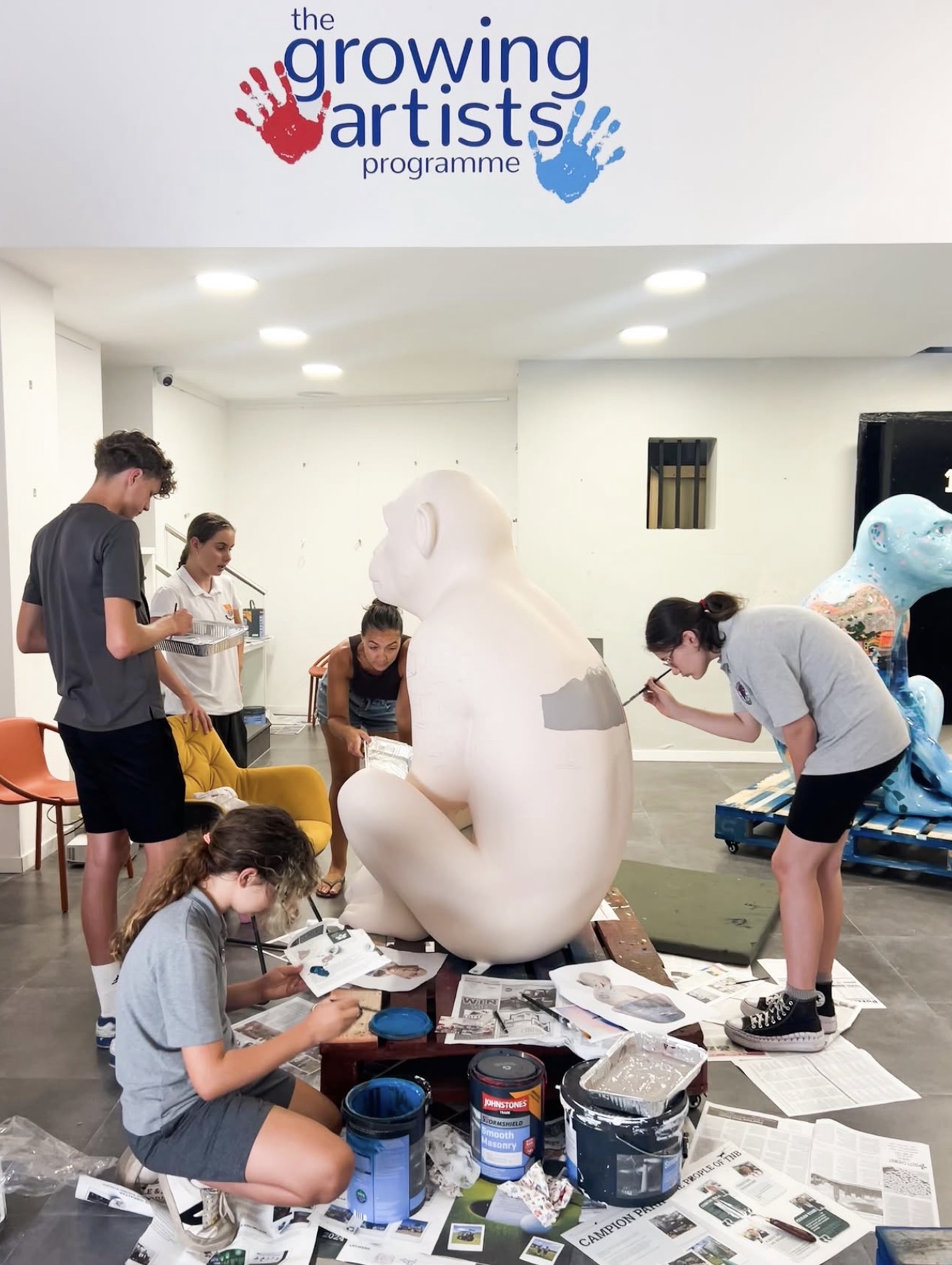 Teenagers from the Youth Group painting a large Barbary macaque sculpture together